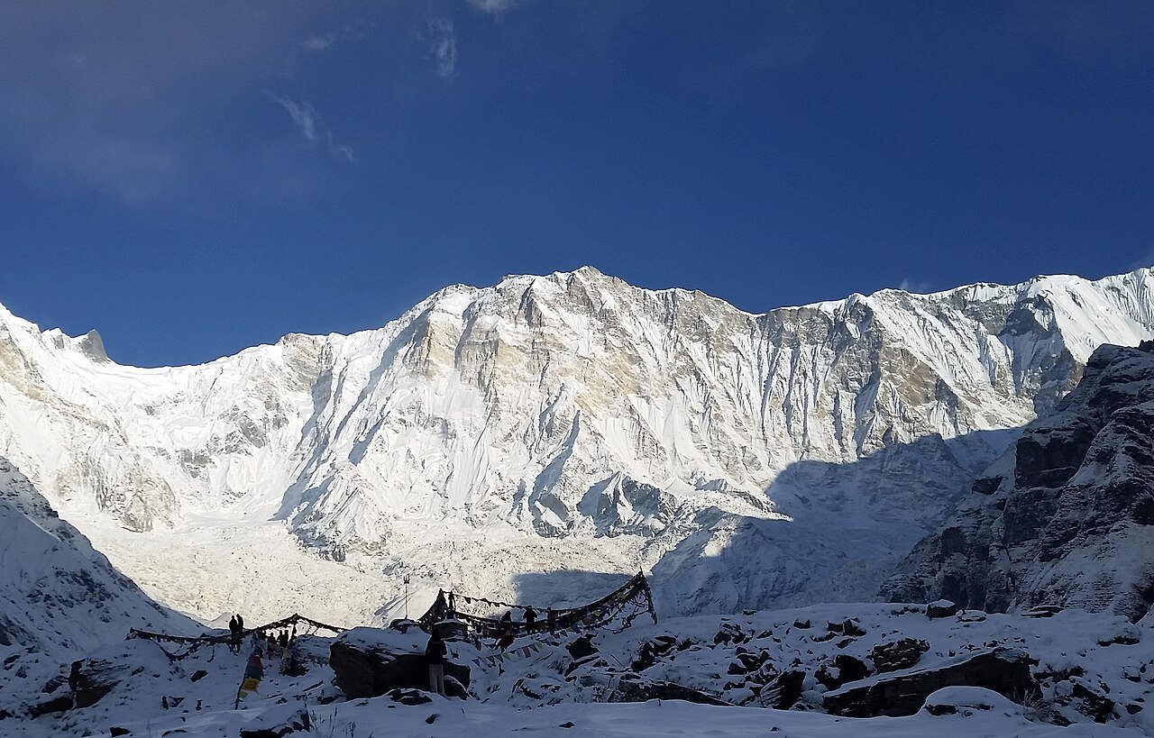 Snow-covered Annapurna I rising over the base-camp valley under a blue sky