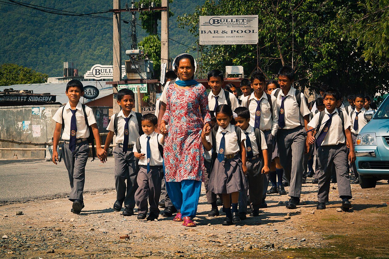A teacher and uniformed schoolchildren outside a school in Pokhara
