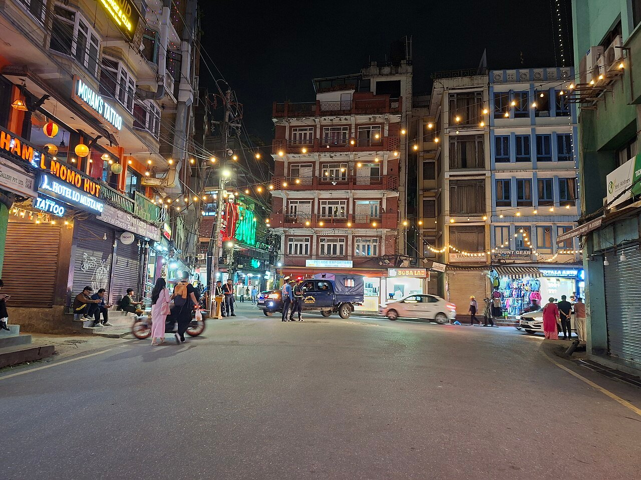 Lit shopfronts and an intersection in Kathmandu’s Thamel neighborhood at night