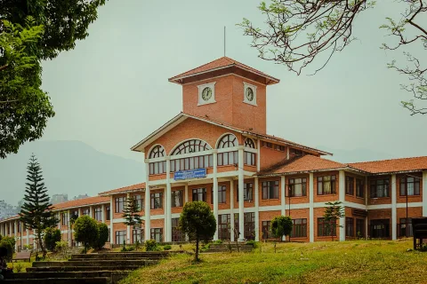 A brick building with a clock tower at Tribhuvan University